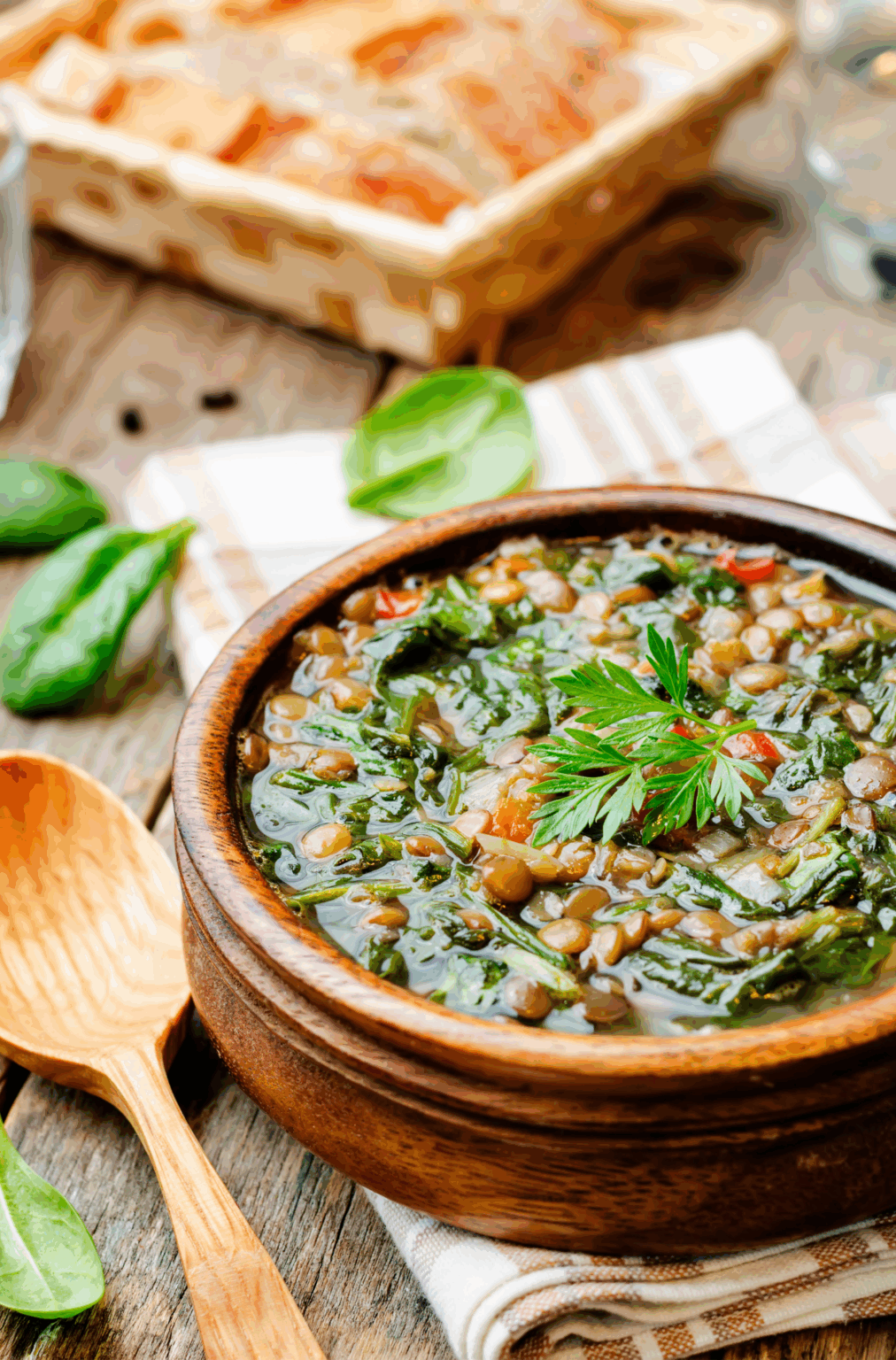 Bol de soupe maison aux lentilles, épinards et légumes frais, source naturelle de magnésium et de fer pour réduire les fringales pendant le cycle menstruel